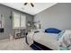 Bedroom with gray walls, natural light from windows, carpet, and a cozy blue bed at 10172 Fire Skye Ave, Las Vegas, NV 89166