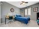 Cozy bedroom with gray walls, a blue bed, a ceiling fan and natural light from the window at 10172 Fire Skye Ave, Las Vegas, NV 89166