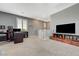 Large upstairs bonus room boasts plush carpet, gray walls, a ceiling fan, and bright light from a window at 10172 Fire Skye Ave, Las Vegas, NV 89166