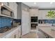 Modern kitchen features stainless steel appliances and attractive blue tiled backsplash at 10172 Fire Skye Ave, Las Vegas, NV 89166