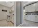 The laundry room features white cabinets, countertops, and a washer and dryer with a decorative rug at 10172 Fire Skye Ave, Las Vegas, NV 89166