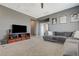 Cozy living room boasts gray walls, plush carpets, a large flat screen television, and comfortable gray sofa at 10172 Fire Skye Ave, Las Vegas, NV 89166