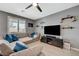 Comfortable living room features a ceiling fan, large sectional, and shelves for decor at 10172 Fire Skye Ave, Las Vegas, NV 89166