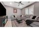 Comfortable living room with a large sectional sofa, ceiling fan, and modern entertainment center at 10172 Fire Skye Ave, Las Vegas, NV 89166