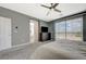Spacious main bedroom features soft carpet, a ceiling fan, and view to bathroom at 10172 Fire Skye Ave, Las Vegas, NV 89166