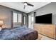 Comfortable main bedroom featuring gray walls, a ceiling fan, and a sliding glass door with a view to the yard at 10172 Fire Skye Ave, Las Vegas, NV 89166