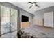 Bright main bedroom boasting a ceiling fan, a wooden dresser with a flat screen television, and a sliding glass door at 10172 Fire Skye Ave, Las Vegas, NV 89166