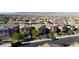 Aerial view of a residential neighborhood with similar homes, mountain views, and green landscaping at 10468 Skye Knoll Ave, Las Vegas, NV 89166