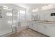 Bathroom featuring double sinks, granite counters, a glass shower, and a soaking tub, offering a luxurious spa-like experience at 10468 Skye Knoll Ave, Las Vegas, NV 89166