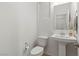 Compact powder room featuring a pedestal sink, toilet, and neutral wall color at 10468 Skye Knoll Ave, Las Vegas, NV 89166