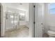 Bright bathroom featuring a glass enclosed shower, toilet, and neutral tile flooring at 10468 Skye Knoll Ave, Las Vegas, NV 89166