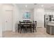 Cozy dining area with a modern table set, tile flooring, and stainless steel appliances nearby at 10468 Skye Knoll Ave, Las Vegas, NV 89166