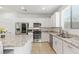 Modern kitchen with stainless steel appliances, white cabinetry, granite countertops and tile flooring at 10468 Skye Knoll Ave, Las Vegas, NV 89166