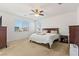 Bright bedroom with neutral carpet, ceiling fan, and ample natural light creating a warm and inviting space at 10468 Skye Knoll Ave, Las Vegas, NV 89166