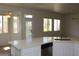 Bright, open kitchen featuring an island with quartz countertops, stainless steel dishwasher, and backyard view at 10732 Cedar Creek Ave, Las Vegas, NV 89134
