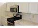Modern kitchen features stainless steel appliances, quartz countertops and white cabinetry at 10732 Cedar Creek Ave, Las Vegas, NV 89134