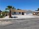 Single-story home with desert landscaping, including mature palm trees and a well-manicured yard at 1075 Greymouth St, Las Vegas, NV 89110