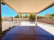 Stamped concrete back patio area covered with a patio roof with landscaping, rock, and an outdoor table set at 11025 Hawk Valley Ave, Las Vegas, NV 89134