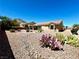 Large backyard with rock landscaping and mature trees under a clear blue sky at 11025 Hawk Valley Ave, Las Vegas, NV 89134