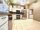 Bright kitchen with modern stainless steel appliances, white cabinets, and tile flooring at 11025 Hawk Valley Ave, Las Vegas, NV 89134