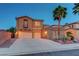 Inviting two-story home with a three-car garage, complimented by lush landscaping and a towering palm tree at 112 Kava Kava St, Henderson, NV 89015