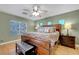 Bright main bedroom featuring a large bed, wood flooring and view to rear exterior at 112 Kava Kava St, Henderson, NV 89015