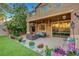 Covered patio features stylish outdoor seating and a view of the landscaped backyard at 112 Kava Kava St, Henderson, NV 89015
