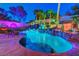 Beautiful backyard pool with rock waterfall feature, tropical plants, and ambient lighting at 112 Kava Kava St, Henderson, NV 89015