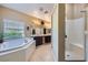 Bright bathroom featuring a separate tub, walk-in shower, and dual sink vanity at 11253 Sanbury Brook St, Las Vegas, NV 89183