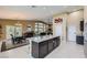 Open concept kitchen with dark cabinetry, a large island, and a dining area with outdoor access at 11253 Sanbury Brook St, Las Vegas, NV 89183
