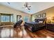 Spacious bedroom features hardwood floors, neutral paint, ceiling fan, and a sitting area with a massage chair at 11253 Sanbury Brook St, Las Vegas, NV 89183