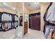 Large walk-in closet with shelving, a mirrored wall and drawers offers ample storage space at 11253 Sanbury Brook St, Las Vegas, NV 89183