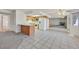 Bright kitchen featuring wood cabinetry, a breakfast bar, and tile flooring leading to a living space with mirrored wall at 1313 Pinto Rock Ln # 202, Las Vegas, NV 89128