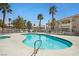 Community pool with palm trees and lounge chairs with multiple lounge chairs at 1313 Pinto Rock Ln # 202, Las Vegas, NV 89128