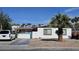 Modest single-story home showcasing desert landscaping, white exterior, and a quaint, gated front yard at 1414 Rexford Pl, Las Vegas, NV 89104