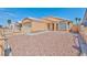 Tan house with low-maintenance desert landscaping, complemented by a gated fence and tiled roof under a blue sky at 1437 Daybreak Dr, Las Vegas, NV 89108