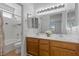 Bright bathroom featuring double sinks, wood cabinets and a shower over tub with white tile surround at 1524 Remembrance Hill St, Las Vegas, NV 89144