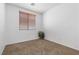 This bedroom features neutral carpet, window with blinds, white walls, and a potted plant at 1524 Remembrance Hill St, Las Vegas, NV 89144