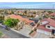 Aerial view of a home with solar panels, desert landscaping, and a three-car garage at 1552 Livingston Dr, Henderson, NV 89012