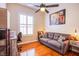 This bedroom has hard wood floors, a gray sofa, and a window for ample lighting at 1552 Livingston Dr, Henderson, NV 89012