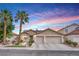 Charming single-story home featuring a two-car garage, desert landscaping, and vibrant sunset skies at 1552 Livingston Dr, Henderson, NV 89012