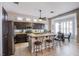 Open kitchen featuring a center island with seating, stainless steel appliances, and dark cabinets at 1552 Livingston Dr, Henderson, NV 89012