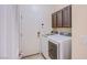 This laundry room includes a washer, dryer, and dark brown storage cabinets for convenience at 1552 Livingston Dr, Henderson, NV 89012