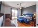 A shot of the main bedroom with a blue bed, bench, and a sliding glass door to the backyard at 1552 Livingston Dr, Henderson, NV 89012