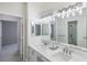 Elegant bathroom featuring double sinks, marble countertop, stylish lighting, and a glass-enclosed shower at 1865 Woodhaven Dr, Henderson, NV 89074