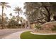 Community entrance with mature landscaping and a stone sign featuring the neighborhood's name at 1865 Woodhaven Dr, Henderson, NV 89074