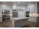 Modern kitchen features white cabinets, stainless steel appliances, and an island for dining and prep at 1865 Woodhaven Dr, Henderson, NV 89074
