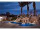 Backyard pool area with a rock waterfall and desert landscaping at 1865 Woodhaven Dr, Henderson, NV 89074