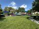 Well-maintained community park featuring lush green grass, playground, shade structures, and walking path at 1901 Rolling Dunes Ct, Las Vegas, NV 89117