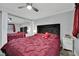 Bedroom featuring a mirrored closet, neutral walls, and a plush red bedspread at 2080 Karen Ave # 1, Las Vegas, NV 89169